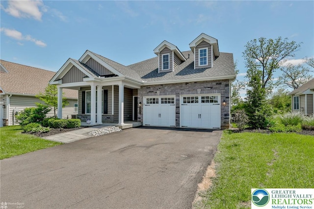 3896 Independence Dr, Easton, PA 18045 - view of front of property with covered porch, stone siding, an attached garage, board and batten siding, and a front lawn