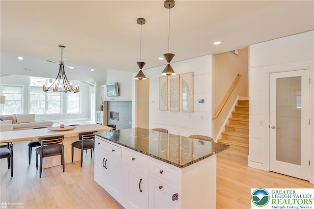 3896 Independence Dr, Easton, PA 18045 - kitchen with a center island, light wood-style floors, white cabinetry, dark stone counters, and a chandelier