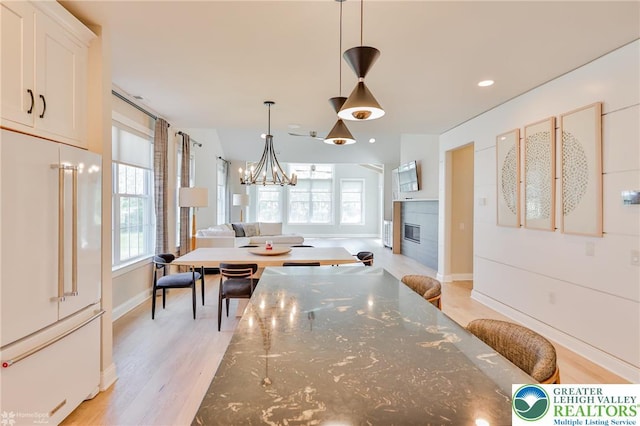 3896 Independence Dr, Easton, PA 18045 - dining space with a glass covered fireplace, light wood-style floors, a chandelier, baseboards, and recessed lighting