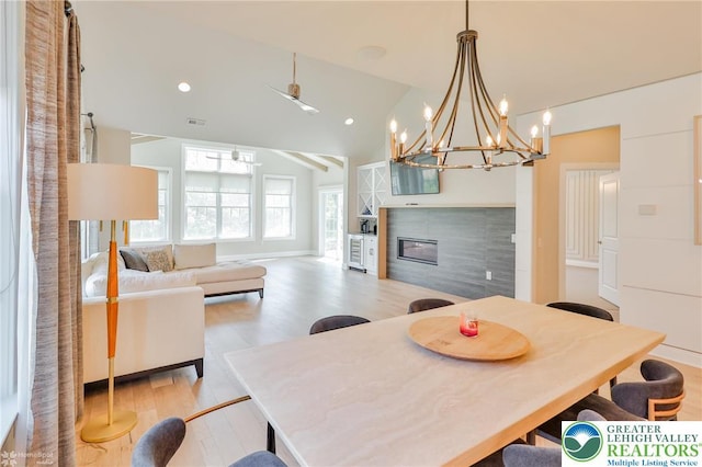 3896 Independence Dr, Easton, PA 18045 - dining room with light wood-style floors, a tile fireplace, vaulted ceiling, recessed lighting, and a chandelier