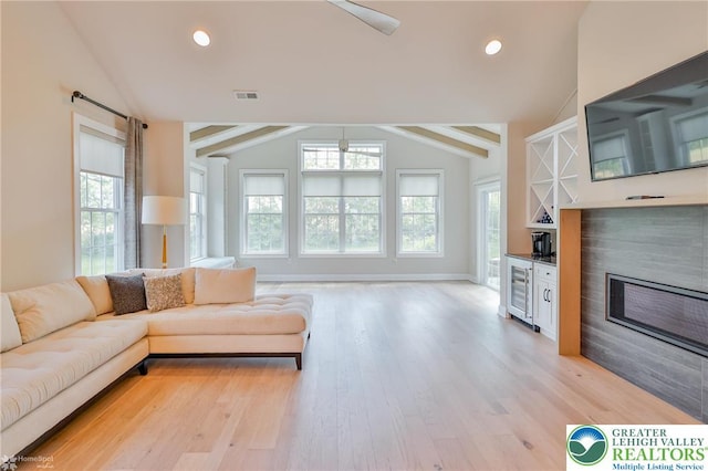 3896 Independence Dr, Easton, PA 18045 - living area featuring lofted ceiling, beverage cooler, light wood-type flooring, a glass covered fireplace, and baseboards