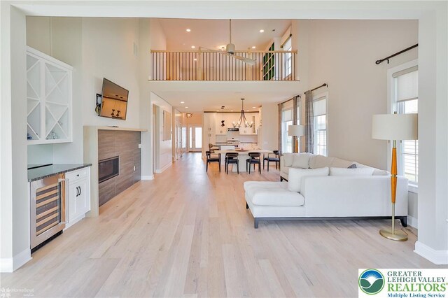 3896 Independence Dr, Easton, PA 18045 - living area featuring wine cooler, light wood-style floors, a high ceiling, baseboards, and ceiling fan