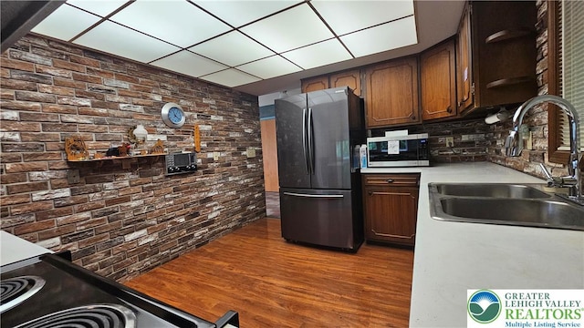 1426 Church St, Fountain Hill Boro, PA 18015 - kitchen featuring freestanding refrigerator, a sink, stainless steel microwave, open shelves, and brick wall