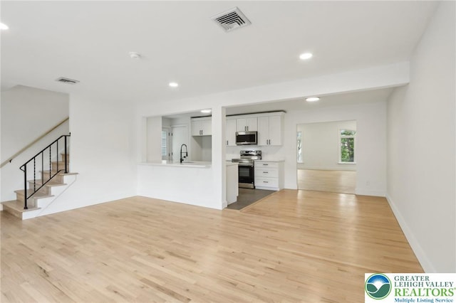 624 E 8th St, Northampton Borough, PA 18067 - unfurnished living room with light wood-style flooring, a sink, recessed lighting, and stairway