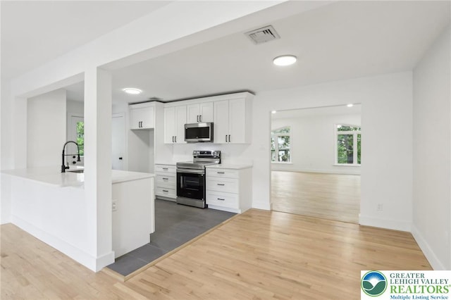 624 E 8th St, Northampton Borough, PA 18067 - kitchen featuring appliances with stainless steel finishes, light wood finished floors, white cabinets, light countertops, and a sink