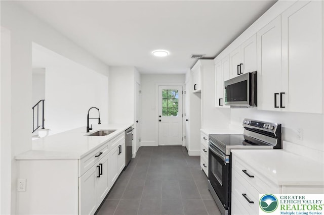 624 E 8th St, Northampton Borough, PA 18067 - kitchen with stainless steel appliances, a sink, light countertops, white cabinets, and dark tile patterned flooring