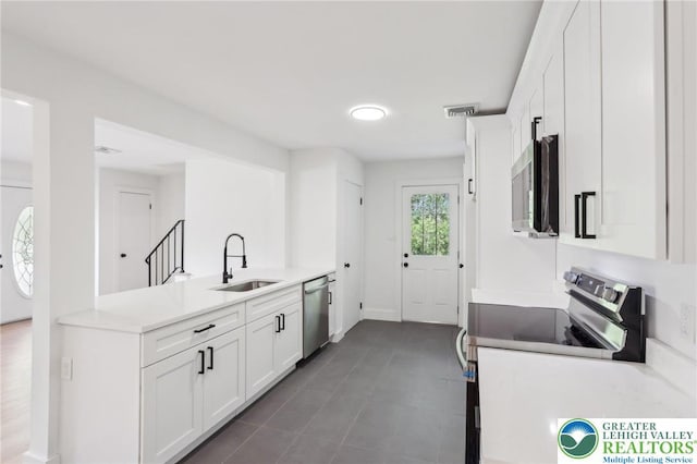 624 E 8th St, Northampton Borough, PA 18067 - kitchen with appliances with stainless steel finishes, a sink, a peninsula, white cabinets, and light countertops