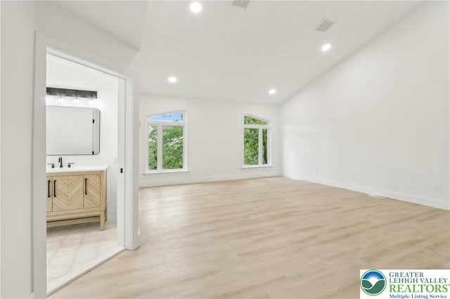 624 E 8th St, Northampton Borough, PA 18067 - unfurnished living room with light wood-style floors, recessed lighting, baseboards, a sink, and lofted ceiling