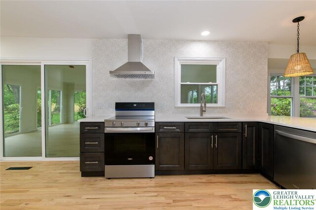 1360 Cherry Ave, Hanover Twp, PA 18017 - kitchen with stainless steel appliances, wall chimney range hood, a sink, light countertops, and hanging light fixtures