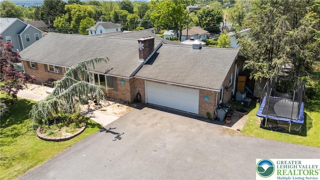 2617 5th St, Bethlehem City, PA 18020 - view of front facade featuring a trampoline, brick siding, an attached garage, asphalt driveway, and a front lawn