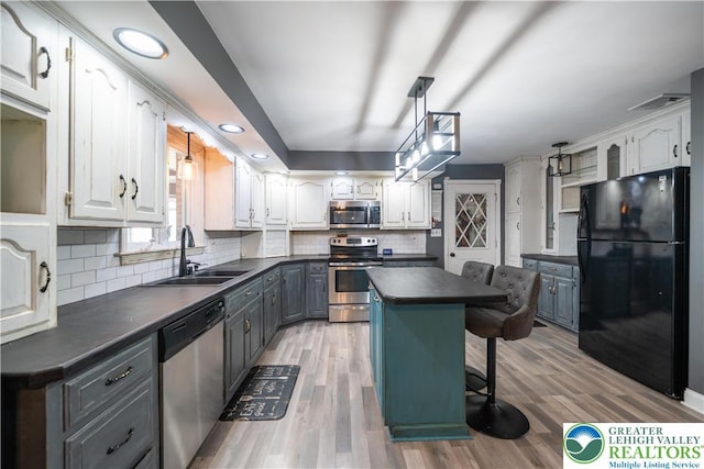 2617 5th St, Bethlehem City, PA 18020 - kitchen featuring stainless steel appliances, a sink, dark countertops, white cabinetry, and a breakfast bar