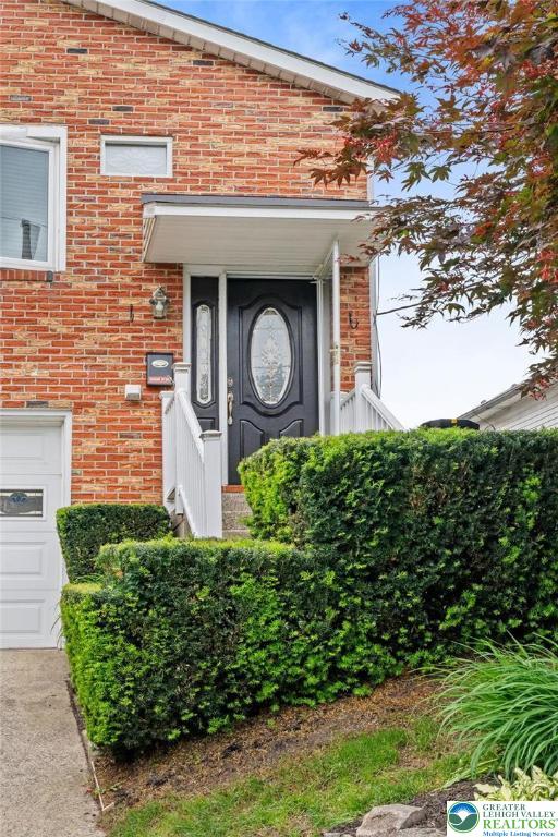 956 E Linden St, Allentown City, PA 18109 - view of exterior entry featuring brick siding and a garage