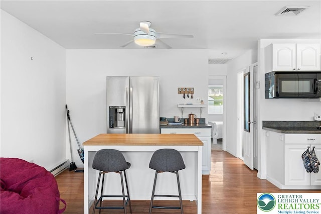956 E Linden St, Allentown City, PA 18109 - kitchen with stainless steel fridge with ice dispenser, black microwave, a breakfast bar area, white cabinetry, and dark wood-type flooring