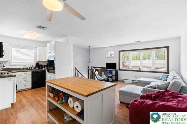 956 E Linden St, Allentown City, PA 18109 - kitchen with black appliances, open floor plan, white cabinetry, and a baseboard heating unit