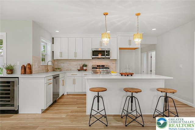1647 4th St, Bethlehem Twp, PA 18020 - kitchen featuring stainless steel appliances, beverage cooler, a breakfast bar, white cabinetry, and decorative backsplash