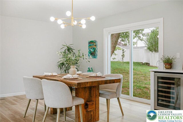 1647 4th St, Bethlehem Twp, PA 18020 - dining room featuring beverage cooler, light wood-type flooring, a chandelier, and baseboards