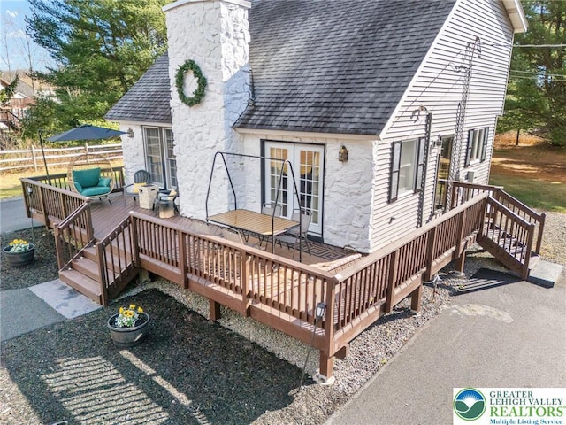 64 Autumn Ln, Penn Forest Twp, PA 18229 - back of property featuring a shingled roof, stone siding, a chimney, an outdoor hangout area, and a deck