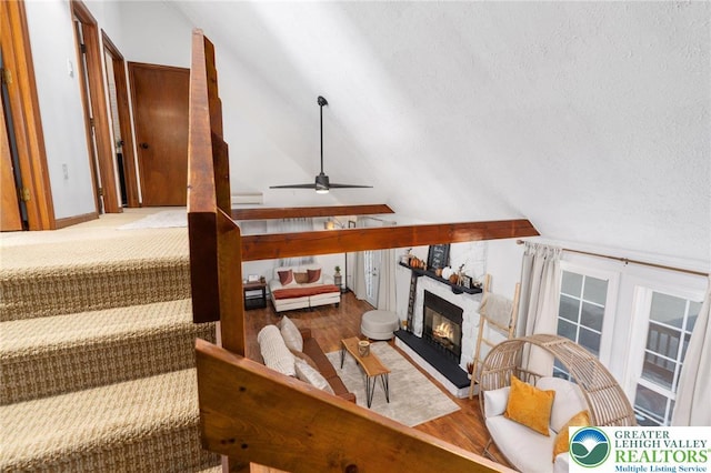 64 Autumn Ln, Penn Forest Twp, PA 18229 - living room featuring lofted ceiling, a fireplace, wood finished floors, a ceiling fan, and a textured ceiling