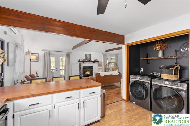 64 Autumn Ln, Penn Forest Twp, PA 18229 - washroom featuring independent washer and dryer, a ceiling fan, a lit fireplace, french doors, and light wood finished floors
