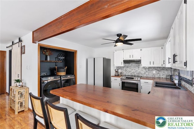 64 Autumn Ln, Penn Forest Twp, PA 18229 - kitchen featuring stainless steel range with electric cooktop, washer and clothes dryer, a peninsula, under cabinet range hood, and white cabinets