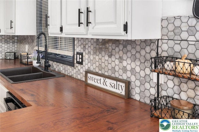 64 Autumn Ln, Penn Forest Twp, PA 18229 - kitchen featuring white cabinets, wood counters, decorative backsplash, and black dishwasher
