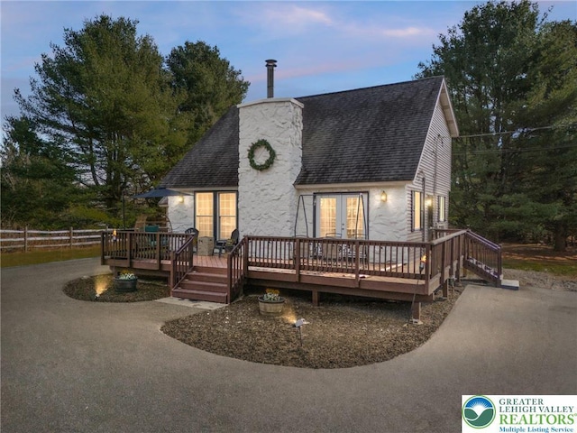 64 Autumn Ln, Penn Forest Twp, PA 18229 - view of front of home featuring roof with shingles, a deck, french doors, and a chimney