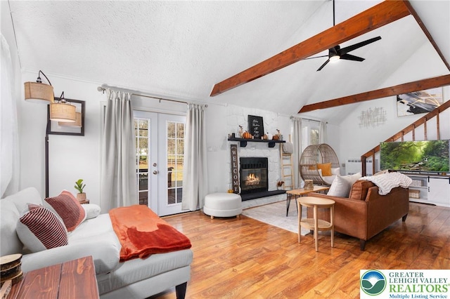 64 Autumn Ln, Penn Forest Twp, PA 18229 - living room with wood finished floors, plenty of natural light, a ceiling fan, a stone fireplace, and a textured ceiling
