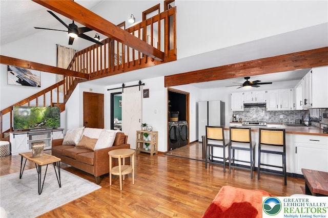 64 Autumn Ln, Penn Forest Twp, PA 18229 - living area with a ceiling fan, a barn door, high vaulted ceiling, beamed ceiling, and light wood-style flooring