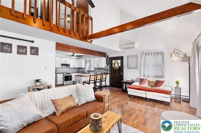 64 Autumn Ln, Penn Forest Twp, PA 18229 - living area with beamed ceiling, a wall mounted AC, light wood finished floors, high vaulted ceiling, and ceiling fan