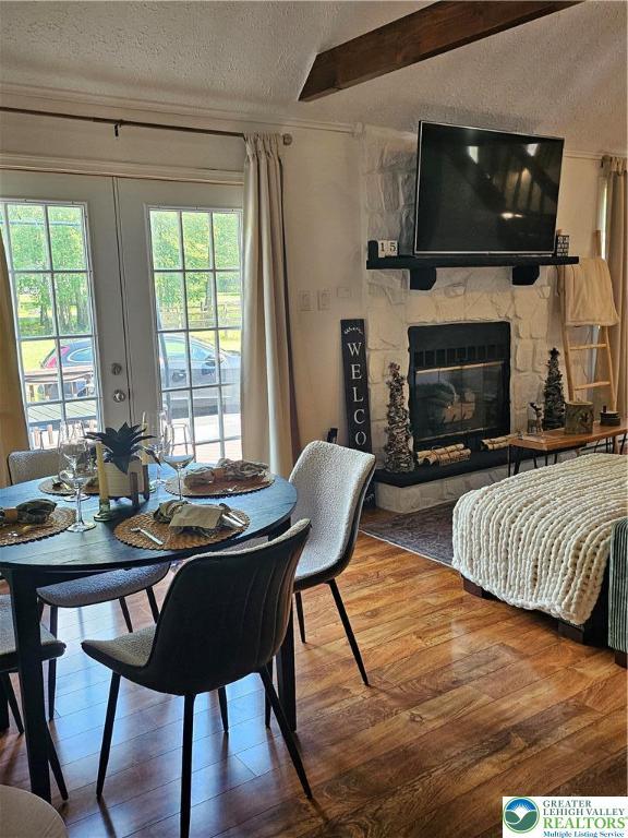 64 Autumn Ln, Penn Forest Twp, PA 18229 - dining room with a textured ceiling, wood finished floors, a fireplace, and beamed ceiling