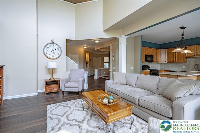 8592 Cascade Rd, Upper Macungie Twp, PA 18031 - living room with ornate columns, dark wood-style flooring, and baseboards