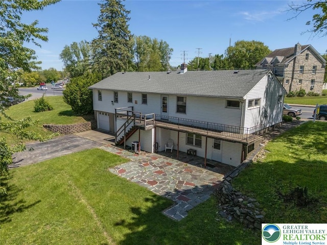 825 Old Philadelphia Rd, Easton, PA 18042 - back of property with a garage, asphalt driveway, a wooden deck, and a lawn
