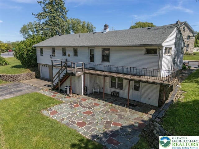 825 Old Philadelphia Rd, Easton, PA 18042 - back of property with stairway, a lawn, a wooden deck, an attached garage, and roof with shingles