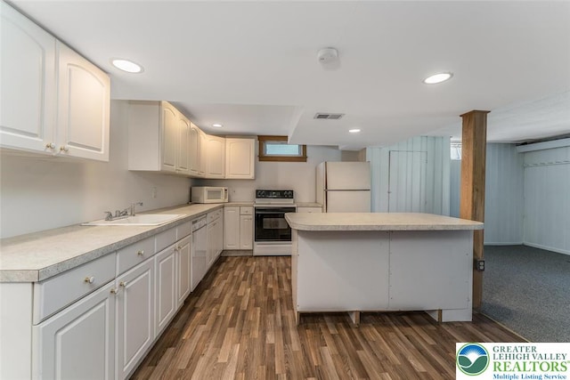 825 Old Philadelphia Rd, Easton, PA 18042 - kitchen featuring white appliances, a sink, dark wood-type flooring, light countertops, and white cabinets