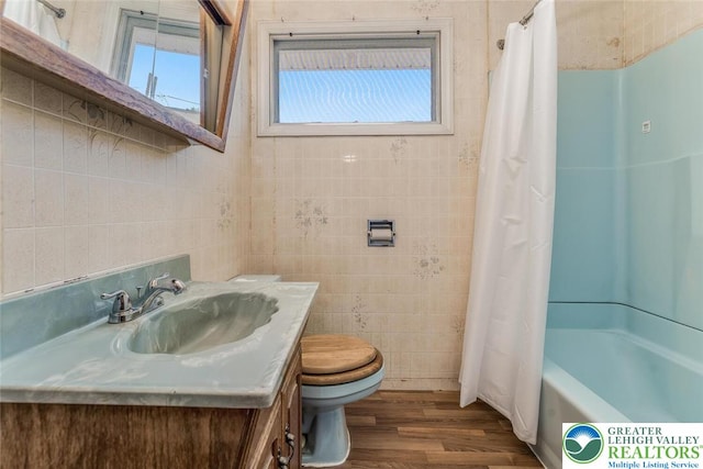 825 Old Philadelphia Rd, Easton, PA 18042 - full bathroom with tile walls, toilet, wood finished floors, vanity, and shower / bathtub combination with curtain