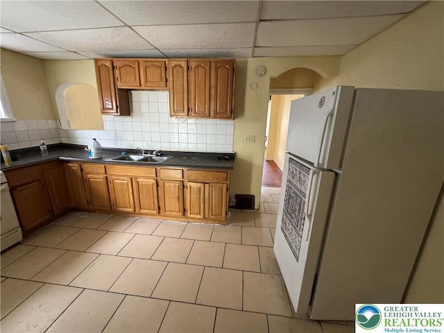 226 Adrain St, Emmaus Boro, PA 18049 - kitchen featuring freestanding refrigerator, a sink, dark countertops, brown cabinetry, and a drop ceiling