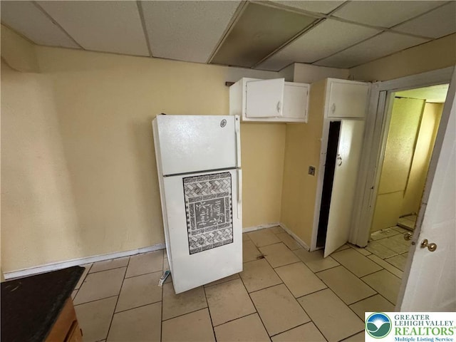 226 Adrain St, Emmaus Boro, PA 18049 - kitchen featuring freestanding refrigerator, white cabinets, a drop ceiling, light tile patterned floors, and baseboards