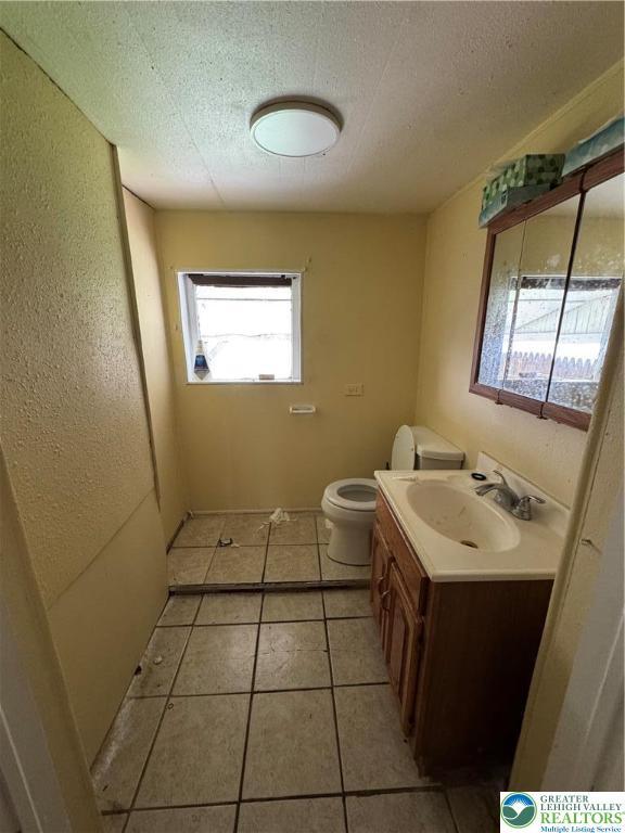 226 Adrain St, Emmaus Boro, PA 18049 - half bathroom featuring vanity, toilet, tile patterned floors, and a textured ceiling