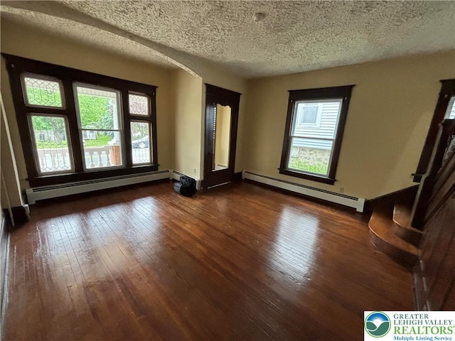 613 S Main St, Bangor Borough, PA 18013 - empty room featuring a baseboard heating unit, dark wood finished floors, plenty of natural light, and a textured ceiling