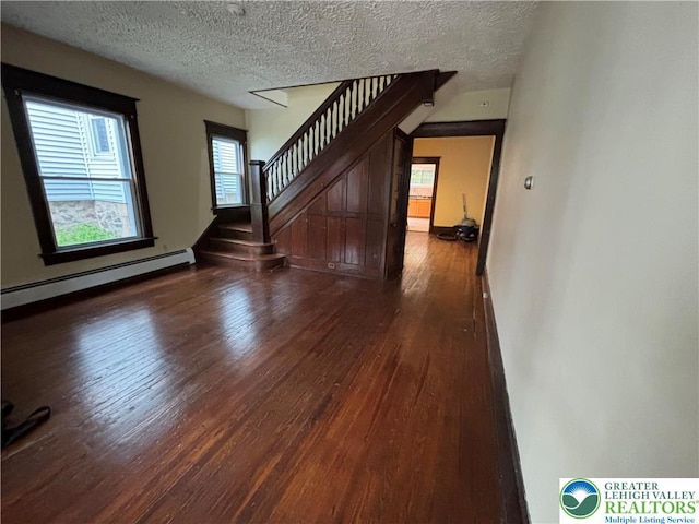 613 S Main St, Bangor Borough, PA 18013 - unfurnished living room with a baseboard heating unit, wood finished floors, stairs, and a textured ceiling