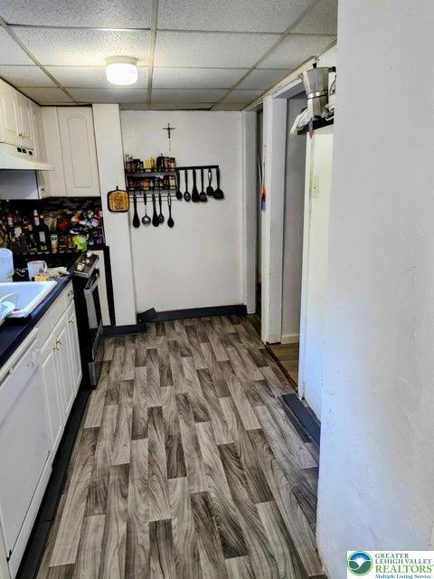 3862 Rte 378, Lower Saucon Twp, PA 18015 - kitchen with white dishwasher, under cabinet range hood, white cabinetry, a paneled ceiling, and range