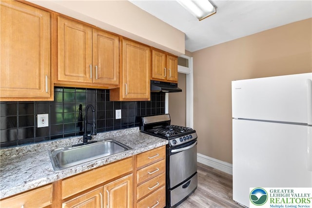 343 N 16th St, Allentown City, PA 18102 - kitchen featuring freestanding refrigerator, stainless steel range with gas stovetop, a sink, under cabinet range hood, and baseboards
