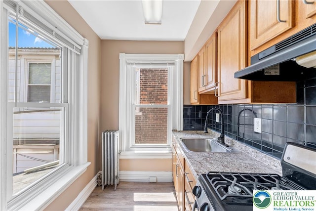 343 N 16th St, Allentown City, PA 18102 - kitchen featuring stainless steel range with gas cooktop, radiator, a sink, under cabinet range hood, and baseboards