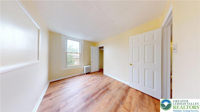 853 N Jordan St, Allentown City, PA 18102 - unfurnished bedroom with radiator heating unit, light wood finished floors, and baseboards
