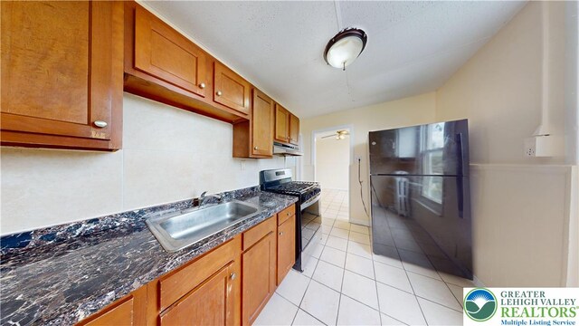 853 N Jordan St, Allentown City, PA 18102 - kitchen featuring gas stove, a sink, under cabinet range hood, brown cabinetry, and light tile patterned floors