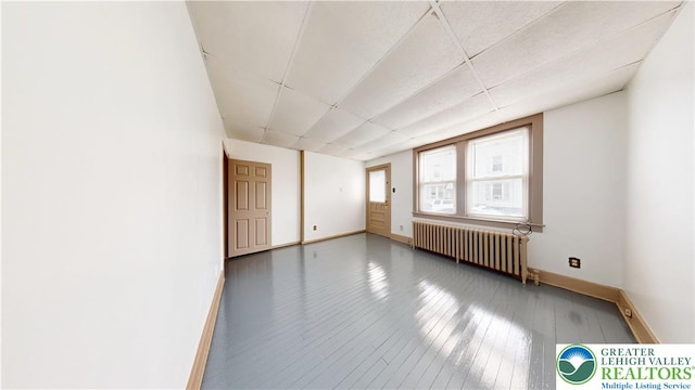 853 N Jordan St, Allentown City, PA 18102 - empty room featuring radiator heating unit, baseboards, a paneled ceiling, and hardwood / wood-style floors