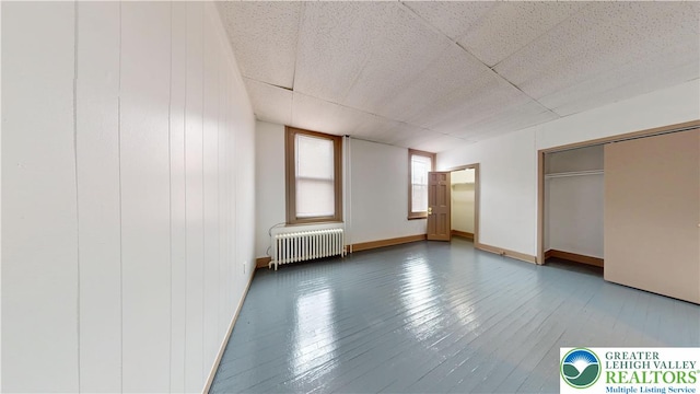 853 N Jordan St, Allentown City, PA 18102 - unfurnished bedroom featuring radiator heating unit, a drop ceiling, hardwood / wood-style flooring, and baseboards