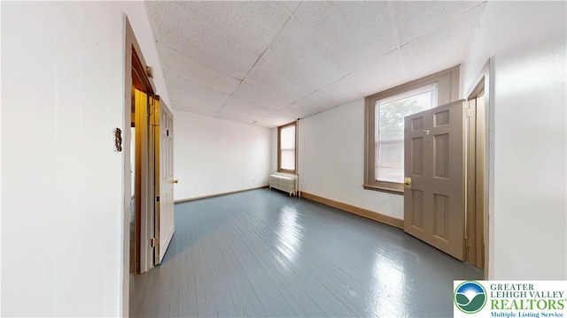 853 N Jordan St, Allentown City, PA 18102 - spare room featuring baseboards, a paneled ceiling, radiator, and wood finished floors
