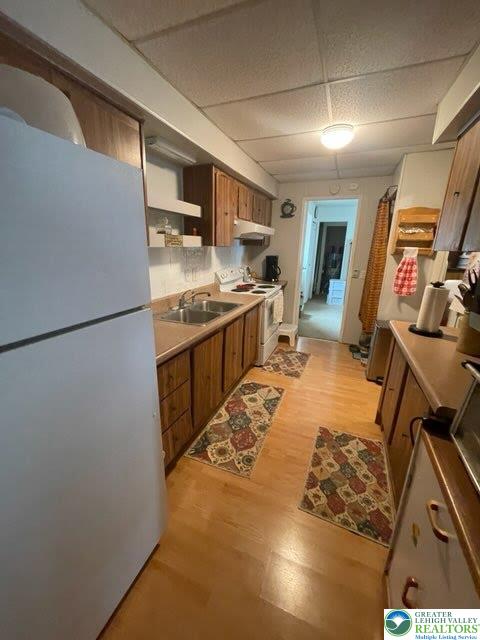 10 Springridge Rd, Moore Twp, PA 18014 - kitchen featuring freestanding refrigerator, white electric stove, brown cabinets, light wood finished floors, and a sink
