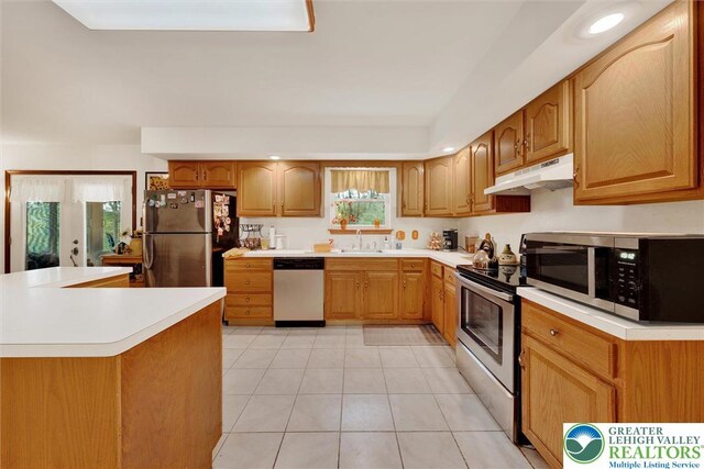 146 Bernadette Dr, Pike, PA 18328 - kitchen with appliances with stainless steel finishes, a sink, under cabinet range hood, light tile patterned floors, and light countertops